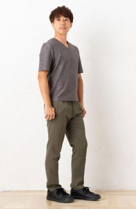 チャコールグレーのTシャツとカーキのパンツを着用した男性