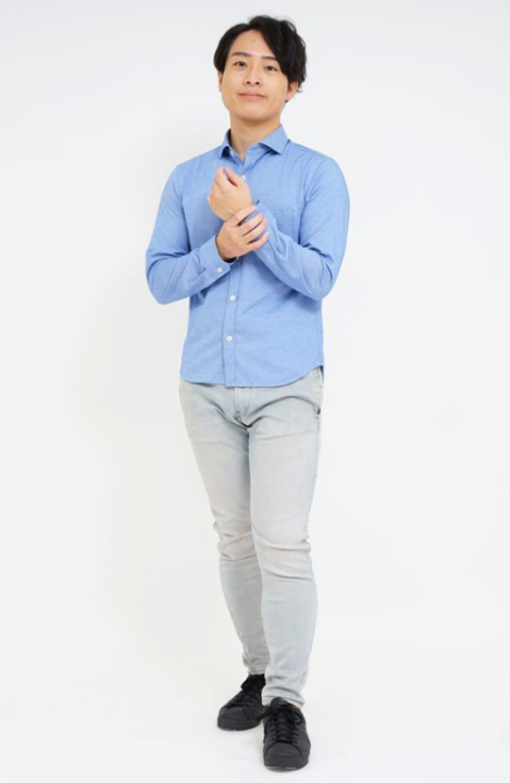 ブルーのシャツとグレーのパンツを着用した男性