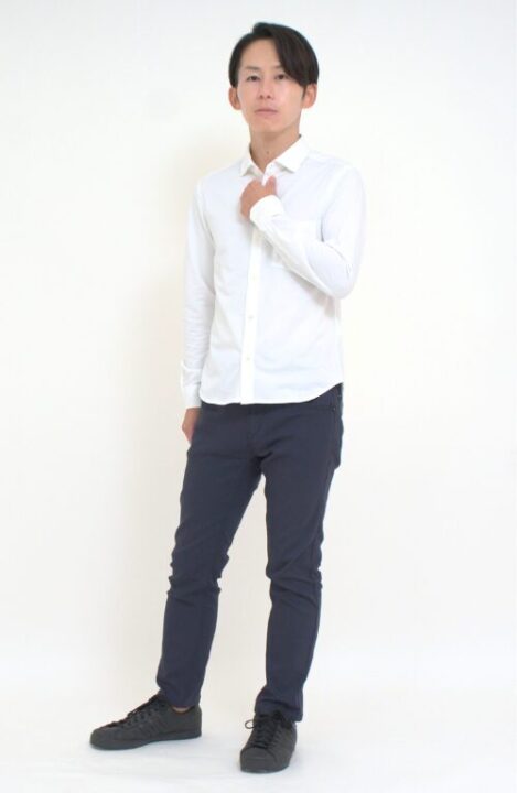 白いシャツと黒いパンツを着用した男性