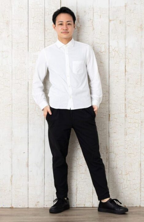 白いシャツと黒いパンツを着用した男性