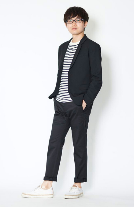 ボーダー柄のカットソーの上に黒いジャケットをはおり、黒色のパンツをはいた男性