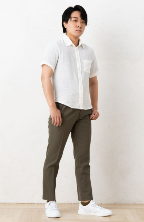 半袖の白いシャツとカーキ色のパンツを着用した男性